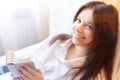 Cute brunette girl is reading small book of poetry in bedroom in morning. Young pregnant woman in the maternity hospital Royalty Free Stock Photo