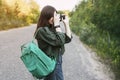 Cute brunette looks at the camera lens. A girl photographs nature. Side view