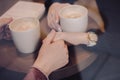 Cute brunette loving couple in cozy warm sweaters on a date at the cafe looking at the phone, using it. cold autumn Royalty Free Stock Photo