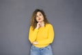 Cute brunette plus size woman with curly hair in yellow sweater Royalty Free Stock Photo