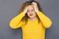 Cute brunette plus size woman with curly hair in yellow sweater Royalty Free Stock Photo