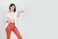 Cute brunette woman 30s in coral jeans, pink tank top and white shirt on white background. High key vertical shot Royalty Free Stock Photo