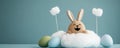 Cute bunny plush toy sitting on fluffy cloud with colorful eggs Royalty Free Stock Photo