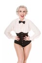 Cute burlesque dancer strikes a pose, dressed in bow tie, frilled shirt & corset, isolated on white Royalty Free Stock Photo