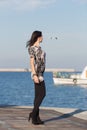 Cute business woman observes white boat in sea