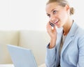 Cute business woman talking on the phone , also using a laptop. Smiling young business woman speaking on the cellphone Royalty Free Stock Photo