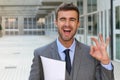 Cute businessman winking and giving an OK sign Royalty Free Stock Photo