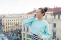 Cute businesswoman in glasses talking on phone and smiling while standing on the roof of the house in the old town Royalty Free Stock Photo