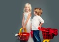 Cute buyer customer client hold shopping cart. Girl and boy children shopping. Couple kids hold plastic shopping basket Royalty Free Stock Photo