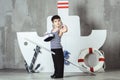 Cabin boy playing with paddle in front of stylized ship