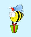 Cute cartoon bee in Santa`s hat with gift box. Royalty Free Stock Photo