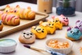 cute cartoon character decorating croissants with colorful frosting