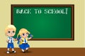 Cute cartoon schoolgirl and schoolboy in uniform with backpacks near blackboard. Royalty Free Stock Photo
