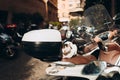 Cute cat resting in bike. Summer outdoors portrait cat on moped on the street. Homeless street young cat lies on seat of