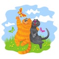 Cute cats in love sitting on the green grass and admiring butterflies Royalty Free Stock Photo