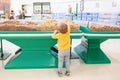 Cute Caucasian baby child choosing nut in supermarket. Funny toddler boy in a grocery store packing produce. Healthy tasty summer Royalty Free Stock Photo