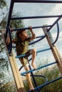 cute caucasian boy climbing on monkey bars. Exercises on the playground. Selective focus on kid Royalty Free Stock Photo