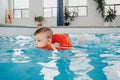 Cute Caucasian child boy in swimming pool with red float ring. Preschool boy training to swim in water indoors. Healthy active Royalty Free Stock Photo