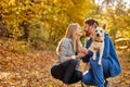 Cute caucasian couple dressed casual hugging and taking a walk in nature with their dog Royalty Free Stock Photo