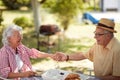 Cute caucasian elderly couple enjoy outdoor, having breakfast and coffee, holding hands Royalty Free Stock Photo