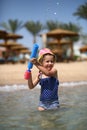 Cute caucasian four year old girl in swimsuit playing with a toy pump in the sea interior Royalty Free Stock Photo