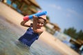 Cute caucasian four year old girl in swimsuit playing with a toy pump in the sea interior Royalty Free Stock Photo