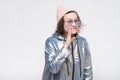 Cute caucasian girl in pink hat and glasses telling gossips or secret on low voice