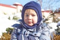 Cute caucasian liittle boy with bright blue eyes in winter clothes and hat hood on winter background. Healthy childhood. Outdoor
