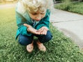 Cute Caucasian preschool girl holding rain worm in hands. Child kid learning studying nature around. Natural biology science.