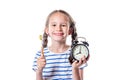 Cute caucasian smiling little girl holding alarm clock and toothbrush against isolated white background. Brush teeth concept Royalty Free Stock Photo