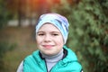 Cute Caucasian teenager boy smiling looking at the camera, wearing a hat and a green vest. Royalty Free Stock Photo