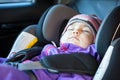 Cute Caucasian toddler boy sleeping in child safety seat in car during road trip Royalty Free Stock Photo