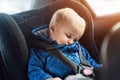 Cute caucasian toddler boy sleeping in child safety seat in car during road trip. Adorable baby dreaming asleep in comfortable Royalty Free Stock Photo