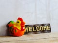 Cute ceramic chicken hen with welcome sign on wooden background Royalty Free Stock Photo