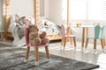 Cute chair with bunny ears and teddy bear in children`s bedroom