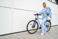 Cute charismatic girl walking with bicycle in the city