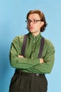 Cute charming young man, student or office clerk in vintage fashion style costume, suit posing isolated on blue Royalty Free Stock Photo