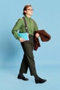 Cute charming young man, student or office clerk in vintage fashion style costume, suit posing isolated on blue Royalty Free Stock Photo