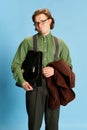 Cute charming young man, student or office clerk in vintage fashion style costume, suit posing isolated on blue Royalty Free Stock Photo