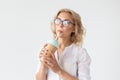 Cute charming young woman is drinking a cocktail from a straw posing against a white background. Royalty Free Stock Photo