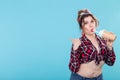 Cute charming young woman in retro clothes is drinking a cocktail from a straw posing against a blue background with Royalty Free Stock Photo