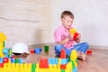 Cute cheeky young boy playing with building blocks Royalty Free Stock Photo