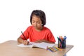 Cute cheerful child drawing using color pencil while sitting at Royalty Free Stock Photo