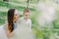 Happy young mother playing and having fun with her little baby son on sunshine warm spring or summer day. Royalty Free Stock Photo