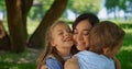 Children hugging happy mother close up. Lovely family picnic in park meadow. Royalty Free Stock Photo