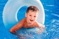 Cute cheerful five-year-old in an inflatable circle for swimming in the pool