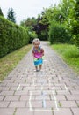 Cute cheerful little girl playing hopscotch on playground outside Royalty Free Stock Photo