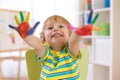 Cute cheerful kid boy showing hands painted in bright colors Royalty Free Stock Photo