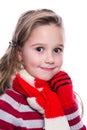 Cute cheerful little girl wearing striped knitted sweater, scarf and mittens isolated on white background. Winter clothes.