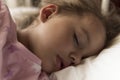 Cute cheerful little 3-4 years preschool baby girl kid sleeping sweetly in white crib during lunch rest time in pink Royalty Free Stock Photo